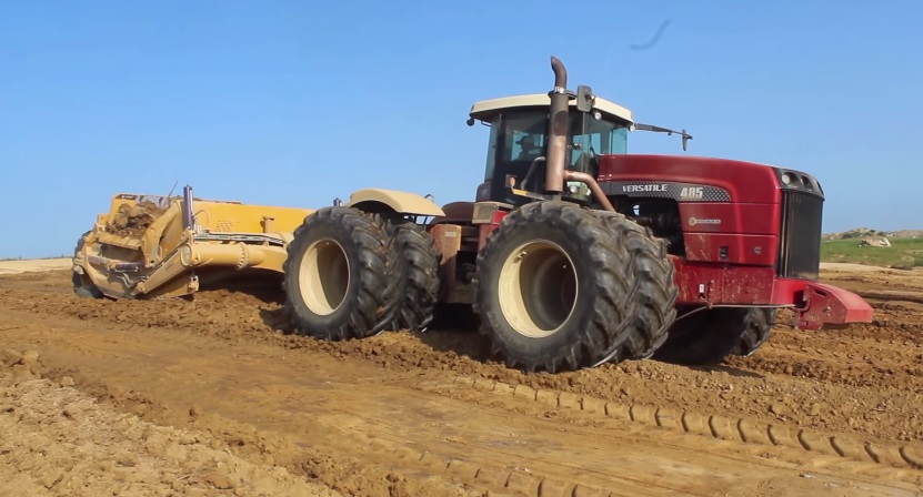 A Versatile 485 tractor pulling a K-Tec 1228 Scraper Pan 