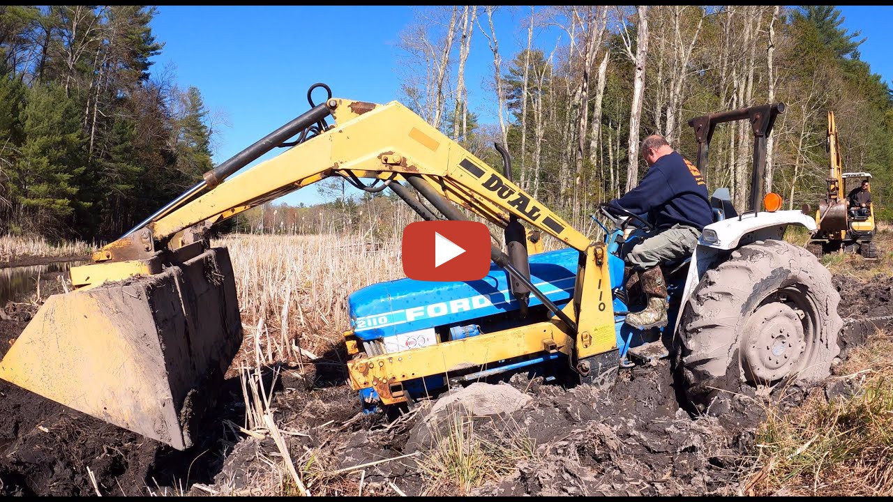 Pulling out a stuck tractor Using a Yanmar b50 excavator to pull a